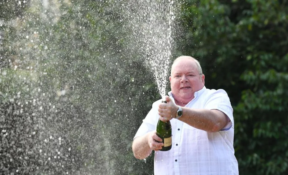 EuroMillions winner Ade Goodchild celebrating by spraying champagne